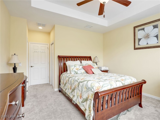 bedroom featuring carpet, visible vents, a raised ceiling, and baseboards