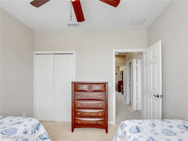 bedroom with light colored carpet, a closet, visible vents, and ceiling fan