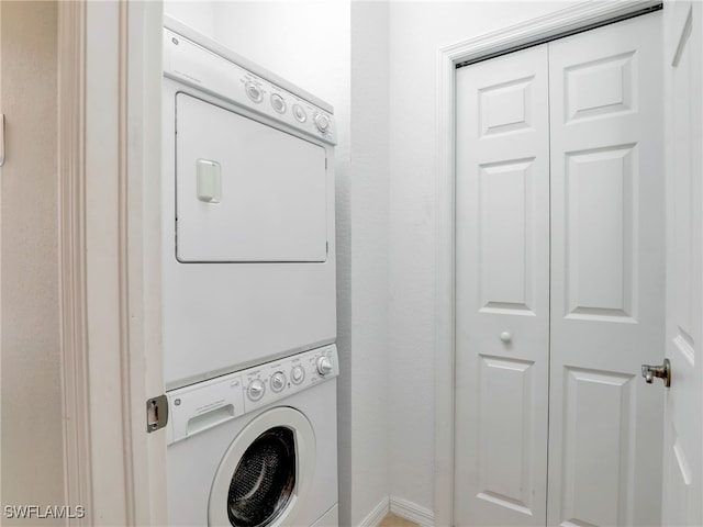 clothes washing area with stacked washer and clothes dryer and laundry area