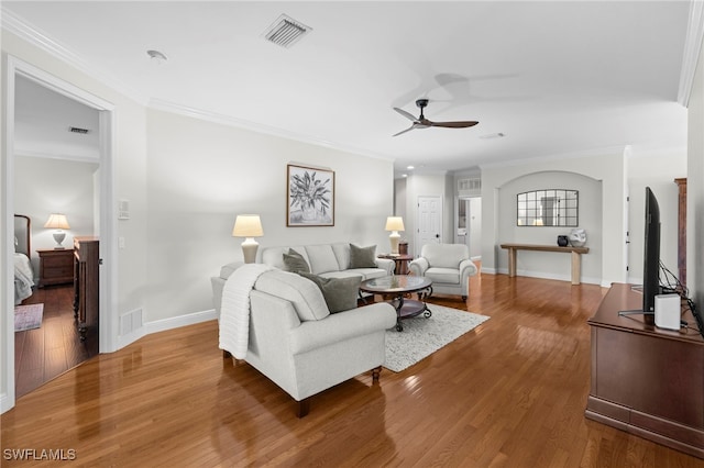 living area featuring crown molding, wood finished floors, and visible vents