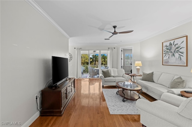 living area featuring ceiling fan, light wood-type flooring, baseboards, and ornamental molding