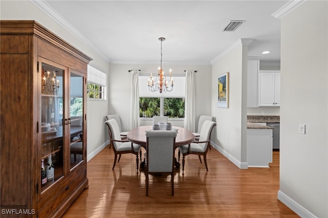 dining area featuring a chandelier, visible vents, wood finished floors, and ornamental molding