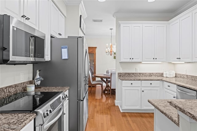 kitchen featuring light wood finished floors, stainless steel appliances, white cabinets, crown molding, and decorative light fixtures