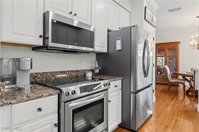 kitchen featuring white cabinetry, crown molding, a notable chandelier, and stainless steel appliances