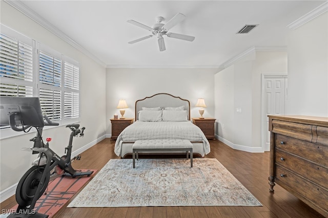 bedroom with crown molding, wood finished floors, visible vents, and baseboards