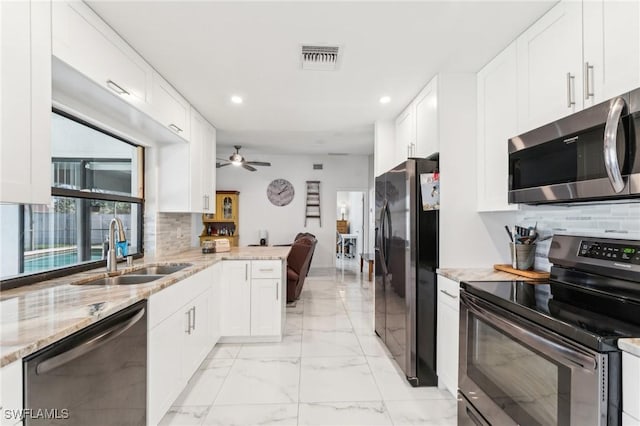 kitchen featuring white cabinets, marble finish floor, appliances with stainless steel finishes, and a sink