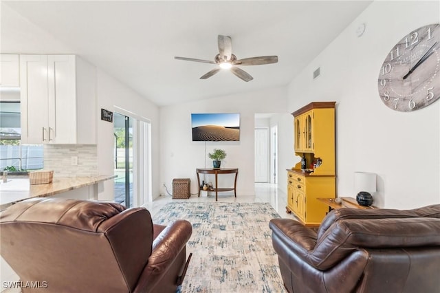 living area featuring vaulted ceiling, a ceiling fan, and visible vents