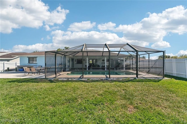 rear view of house with a patio, fence, a lawn, and a lanai