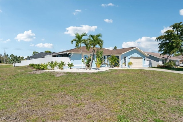 ranch-style home with a front yard, fence, a garage, and driveway