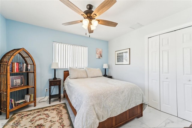 bedroom with a closet, marble finish floor, and ceiling fan