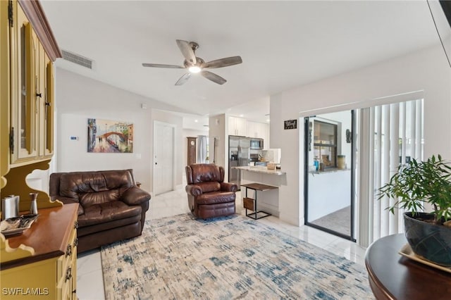 living area with light tile patterned floors, visible vents, a wealth of natural light, and ceiling fan