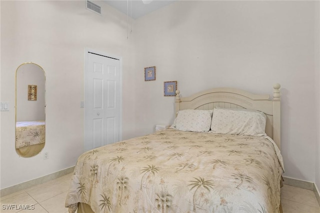 bedroom with tile patterned flooring, baseboards, visible vents, and arched walkways