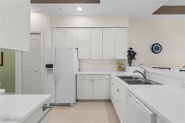 kitchen featuring a sink, white cabinetry, white appliances, light countertops, and light tile patterned floors