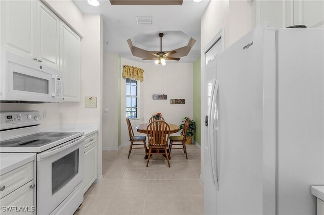 kitchen with visible vents, light countertops, white appliances, white cabinetry, and a raised ceiling