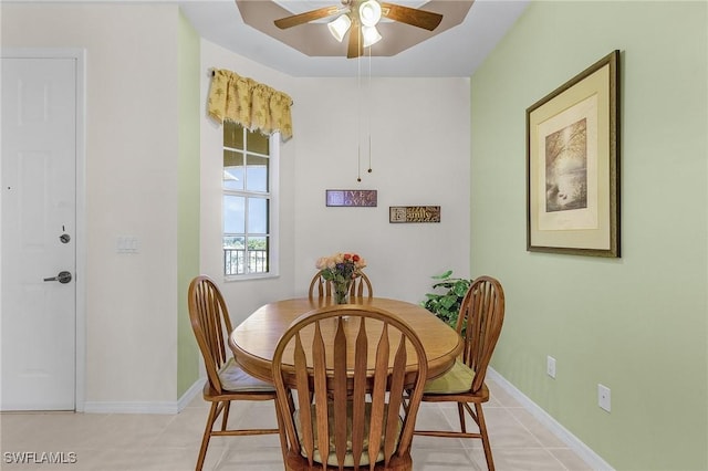 dining space with light tile patterned floors, baseboards, and a ceiling fan