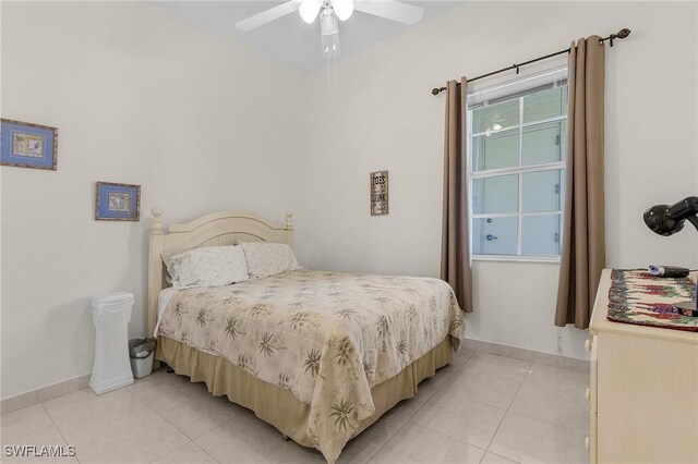 bedroom featuring light tile patterned floors, baseboards, and a ceiling fan