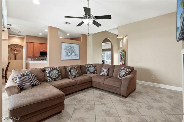 living room featuring baseboards, light tile patterned flooring, recessed lighting, arched walkways, and ceiling fan