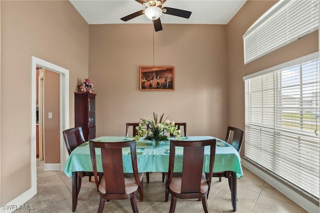 dining room with light tile patterned flooring, baseboards, and ceiling fan