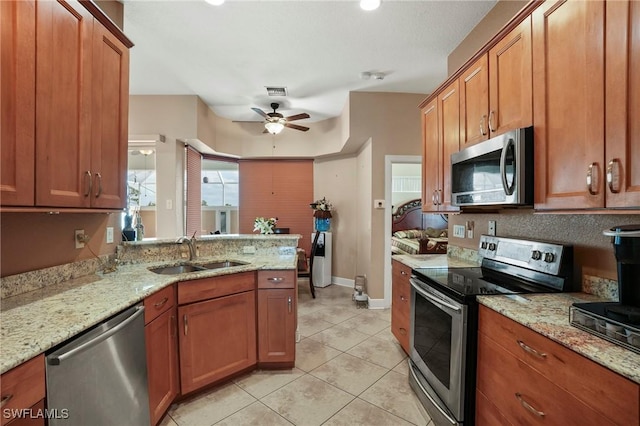 kitchen with brown cabinetry, appliances with stainless steel finishes, and a sink