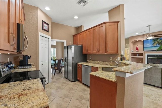 kitchen with visible vents, a peninsula, a sink, appliances with stainless steel finishes, and open floor plan