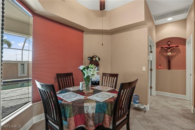 tiled dining room featuring baseboards