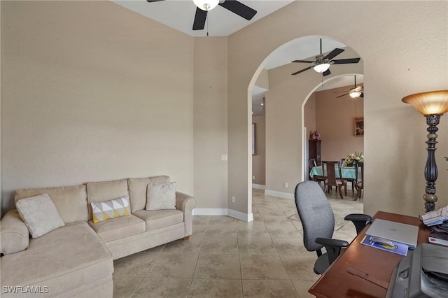 tiled home office with baseboards, arched walkways, and ceiling fan