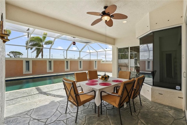 sunroom / solarium with a swimming pool and a ceiling fan