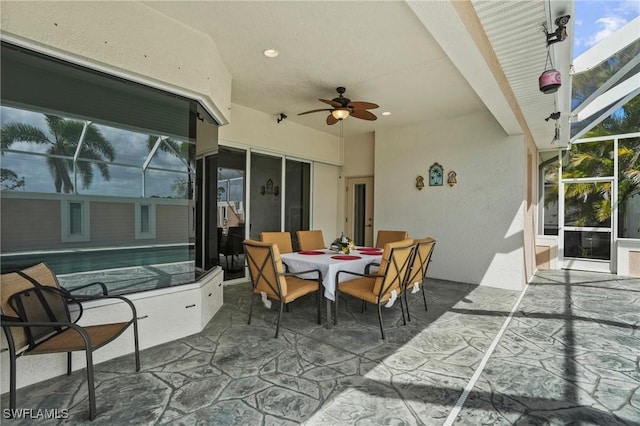 view of patio with a lanai, outdoor dining area, an outdoor pool, and ceiling fan