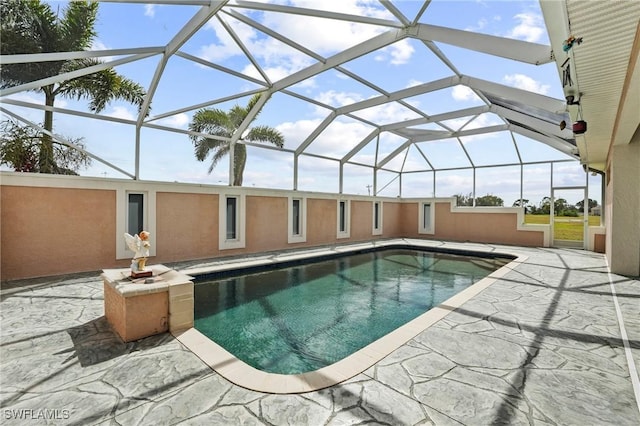 pool with glass enclosure and a patio