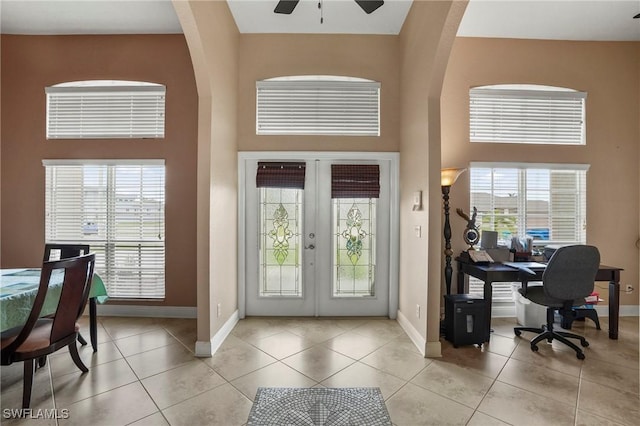 entryway with light tile patterned floors, french doors, a high ceiling, and ceiling fan