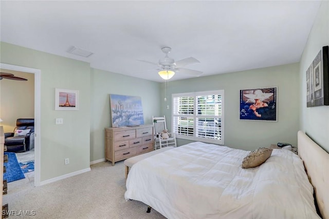 bedroom featuring light colored carpet, baseboards, and ceiling fan