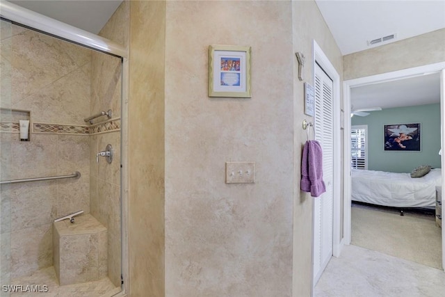 ensuite bathroom featuring a stall shower and a ceiling fan