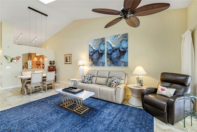 living area with vaulted ceiling, a ceiling fan, and baseboards