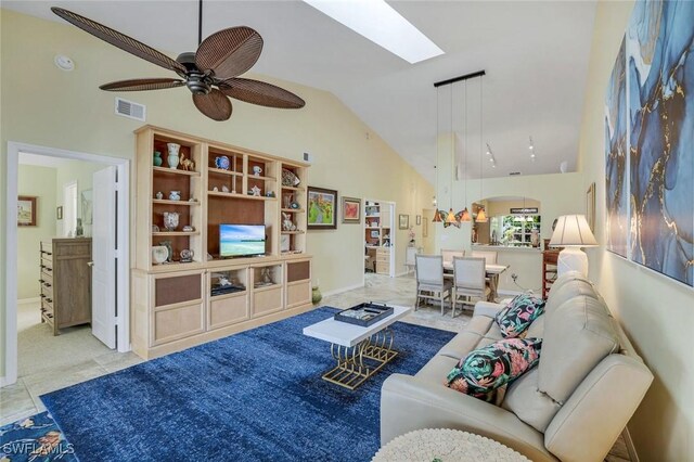 living area featuring high vaulted ceiling, a skylight, visible vents, and a ceiling fan