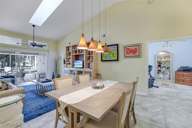 dining area with ceiling fan, high vaulted ceiling, a skylight, visible vents, and baseboards