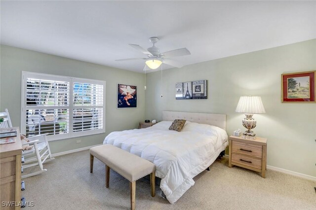 bedroom with light colored carpet, ceiling fan, and baseboards