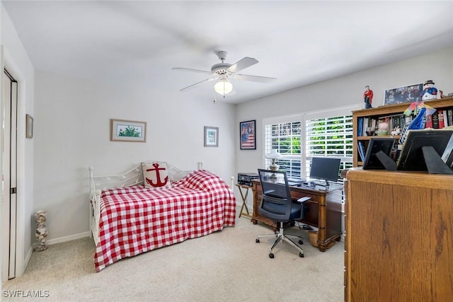 bedroom with carpet, an office area, ceiling fan, and baseboards