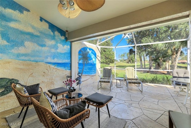 view of patio featuring glass enclosure and a ceiling fan