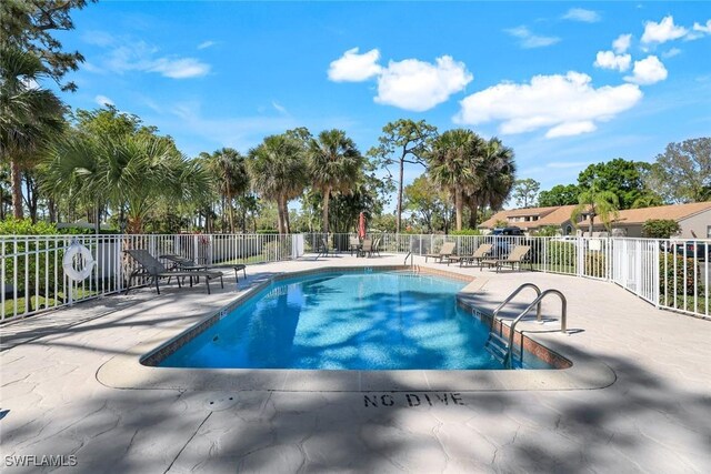 community pool featuring fence and a patio area