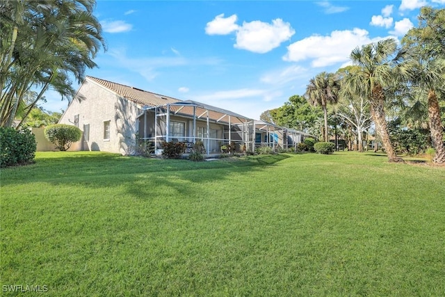 view of grassy yard featuring a lanai