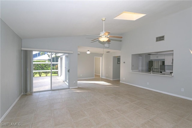 unfurnished living room featuring a skylight, visible vents, ceiling fan, and baseboards