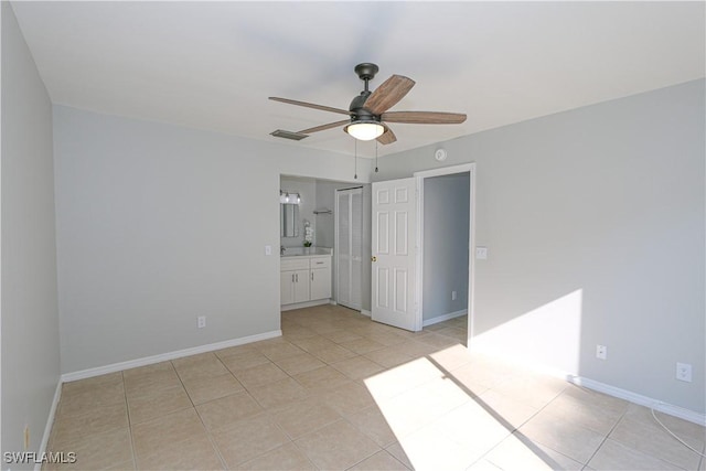 unfurnished bedroom with light tile patterned floors, ensuite bath, visible vents, and baseboards