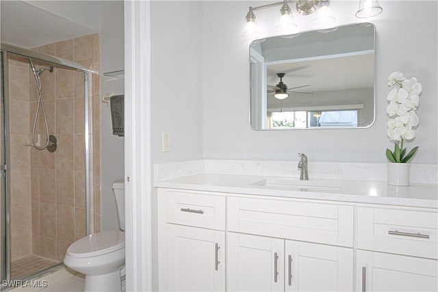 bathroom featuring vanity, a shower stall, toilet, and a ceiling fan