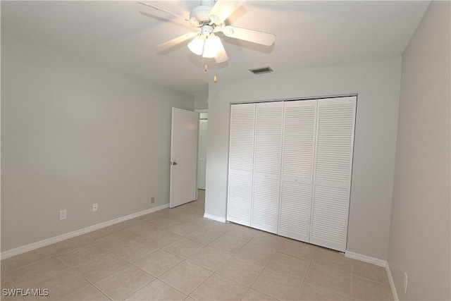 unfurnished bedroom featuring a closet, visible vents, light tile patterned flooring, ceiling fan, and baseboards