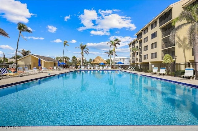 pool with a patio area and fence