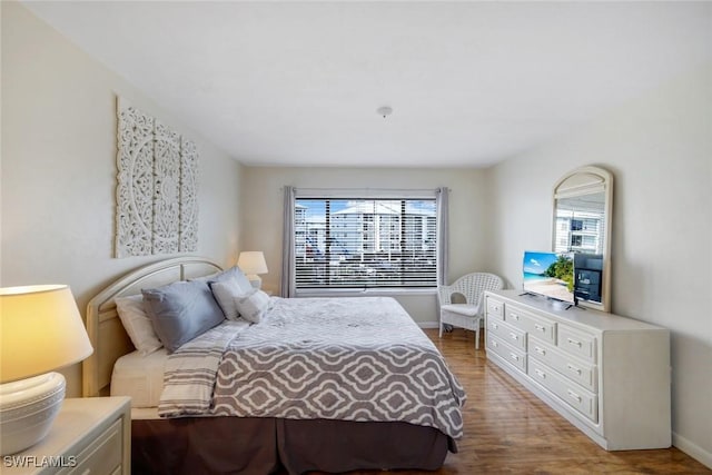 bedroom featuring wood finished floors and baseboards