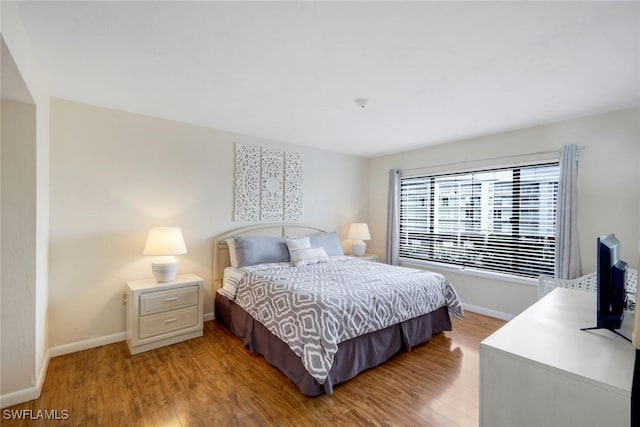 bedroom with light wood-type flooring and baseboards