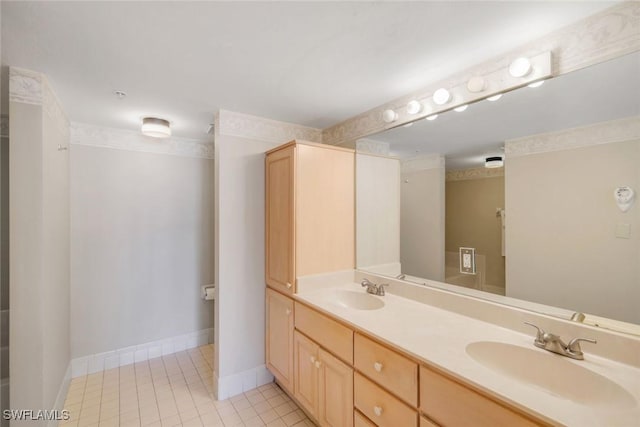 full bathroom with double vanity, a sink, baseboards, and tile patterned floors