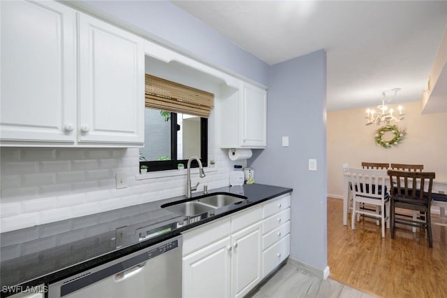 kitchen with a notable chandelier, decorative backsplash, white cabinets, a sink, and dishwasher