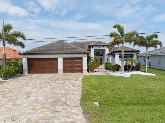 prairie-style house featuring a garage, a front lawn, and stucco siding